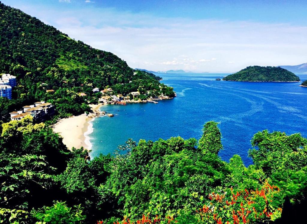 a view of a beach with trees and water at Porto Real Suites Mangaratiba in Mangaratiba