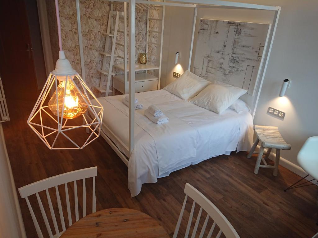 a bedroom with a large white bed and a lamp at Hotel San Nikolas in Hondarribia