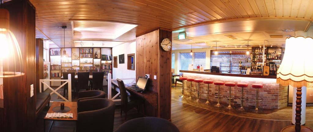 a bar in a restaurant with a counter and chairs at Finlandia Hotel Airport Oulu in Kempele