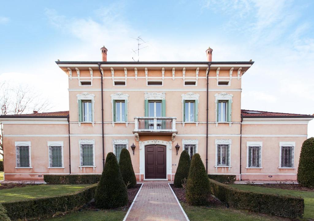 een groot roze huis met een oprit bij B&B Residence il Ciliegio , Via Villa Superiore 93 Luzzara in Luzzara