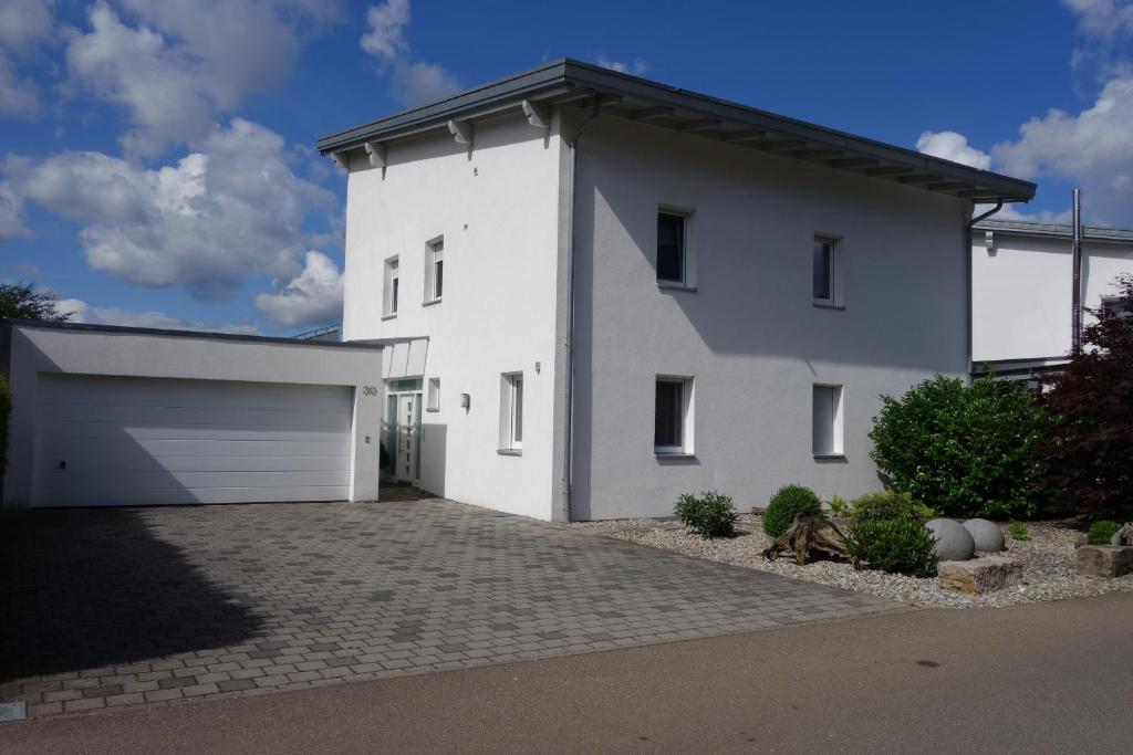 a white house with a garage at Ferienwohnung Himmlingen in Aalen