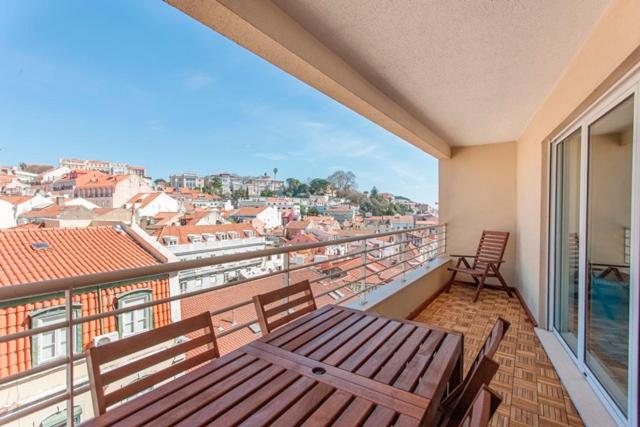 リスボンにあるHang your Hatの木製ベンチ付きのバルコニーから市街の景色を望めます。