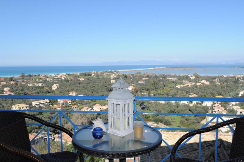 een tafel met licht op een balkon met uitzicht op de oceaan bij Lefkas Dream in Lefkada