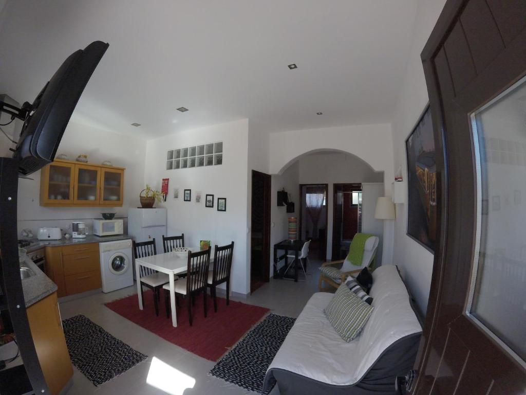 a living room and kitchen with a couch and a table at Stella's House in Nazaré