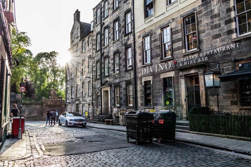 a street with a car parked in front of a building at Grassmarket apartment in Edinburgh