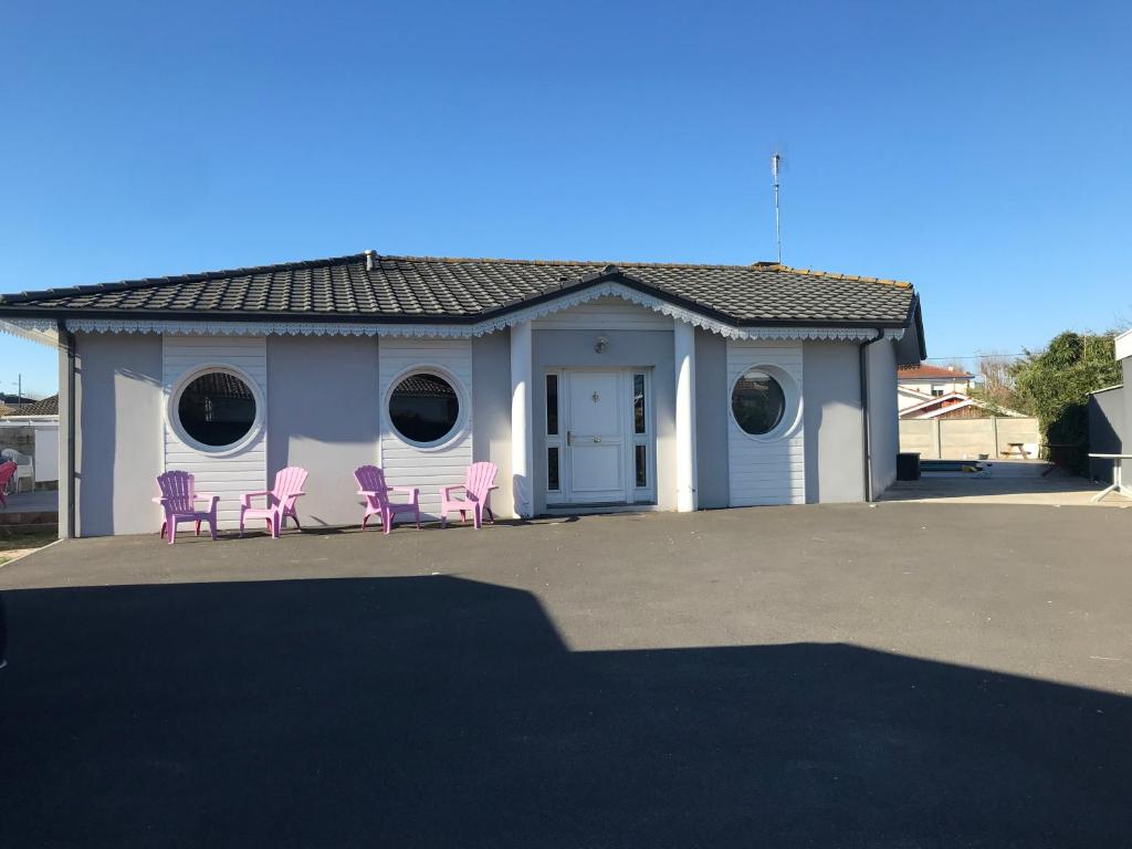 a house with pink chairs in front of it at villa patio 150M² in Andernos-les-Bains