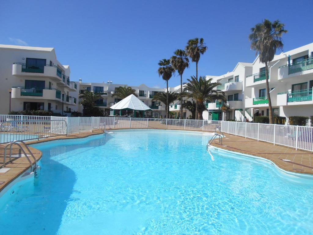 una gran piscina frente a algunos edificios de apartamentos en RealRent Costa Teguise Beach, en Costa Teguise