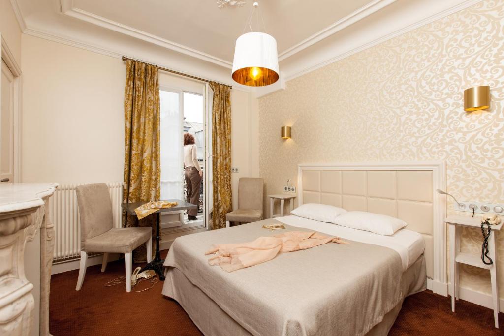 a bedroom with a bed with a robe on it at Hotel Bonaparte in Paris