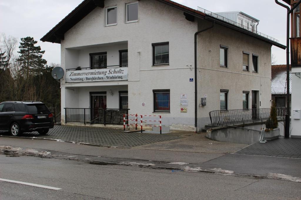 a white building with a car parked in front of it at ZV-Scholtz Gästehaus Neuötting Simbacher Straße 7 in Neuötting