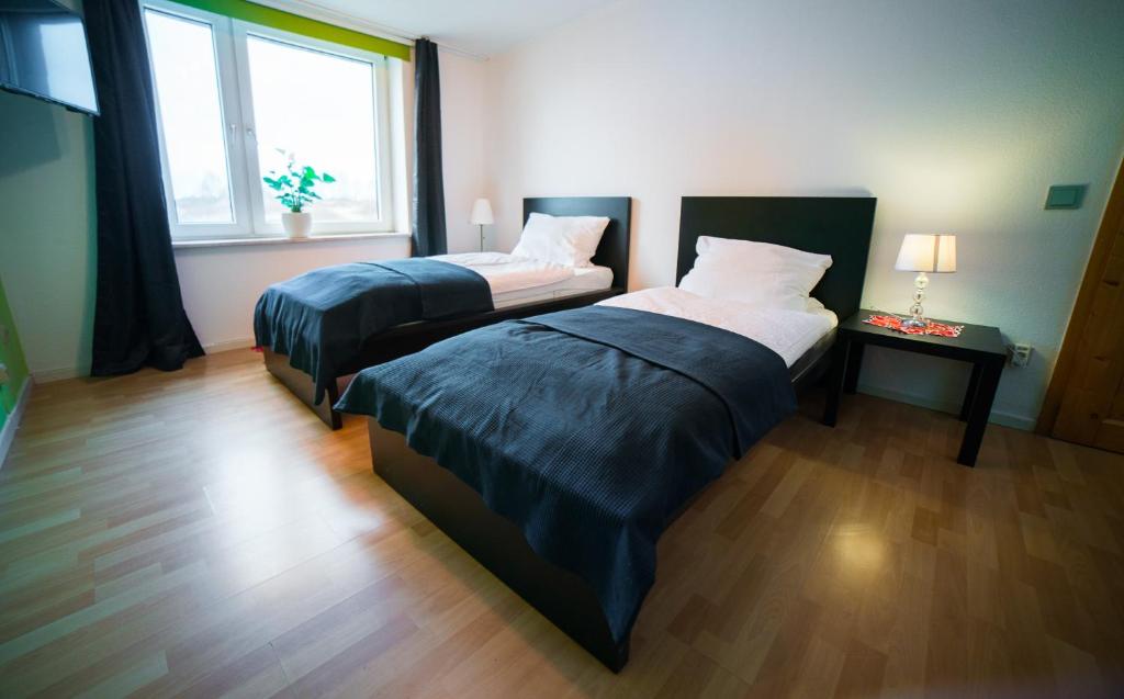 a bedroom with two beds and a window at Löwen Unterkunft Braunschweig in Braunschweig