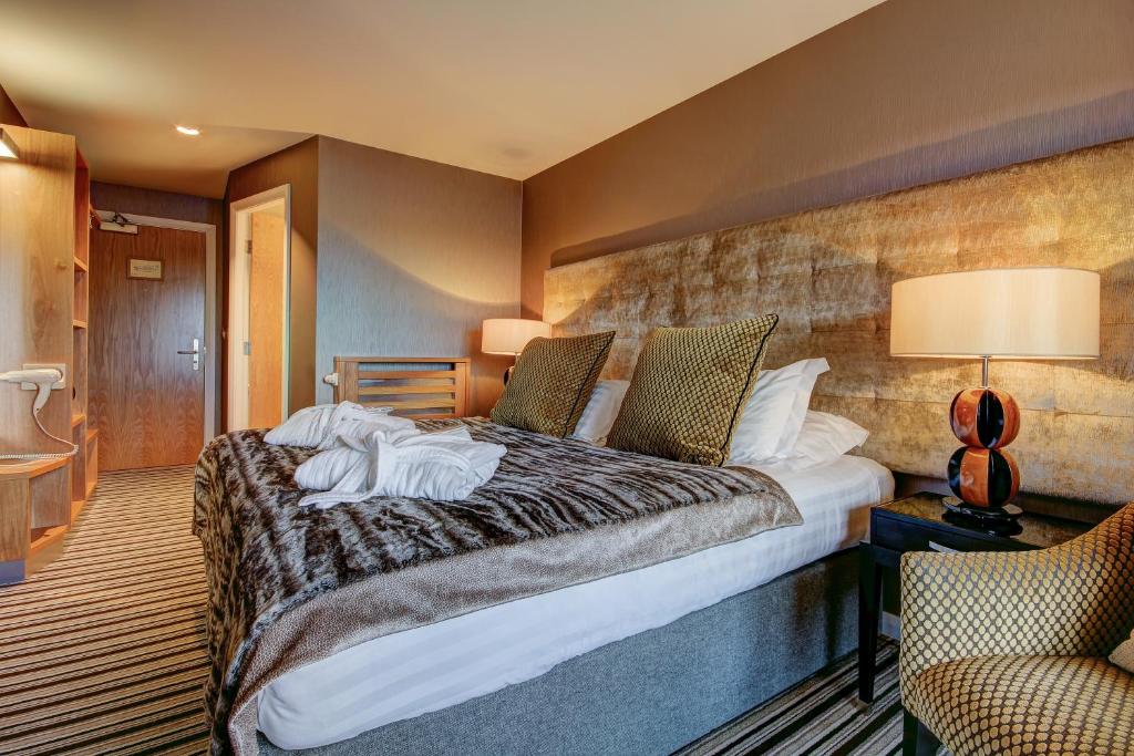 Una habitación de hotel con una cama con toallas. en Ingliston Country Club Hotel, en Bishopton