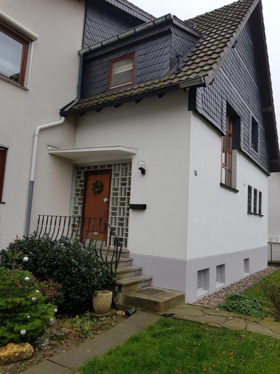 una casa blanca con techo negro en Ferienwohnung, Monteurwohnung "Strunde", en Bergisch Gladbach