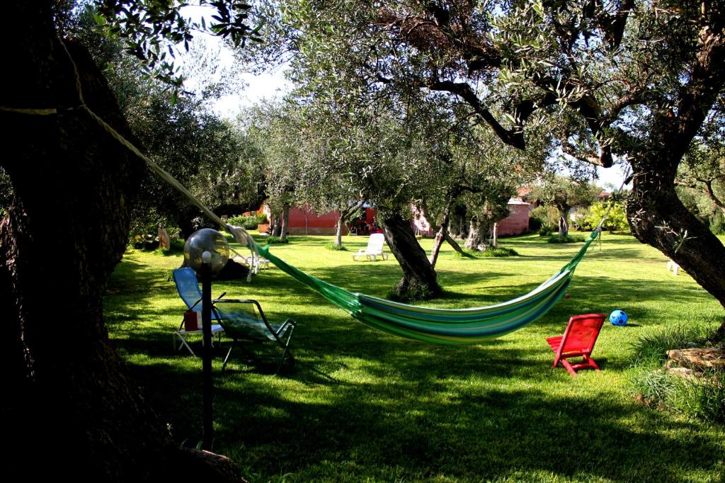 a green hammock in a park with trees at Case Vacanza la Bella in Sciacca