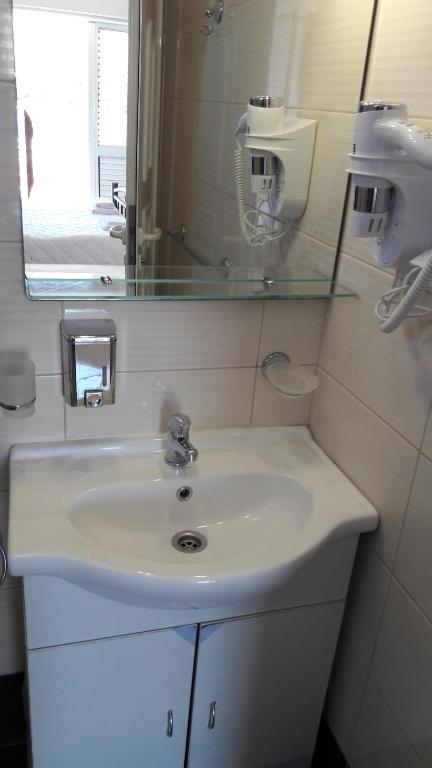 uma casa de banho com um lavatório branco e um espelho. em Villa Espero em Trogir