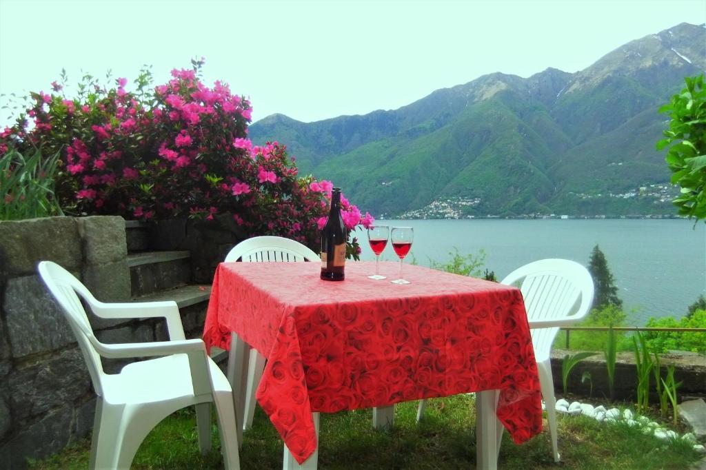 a red table with two glasses of wine on it at casa camelie in Pino Lago Maggiore