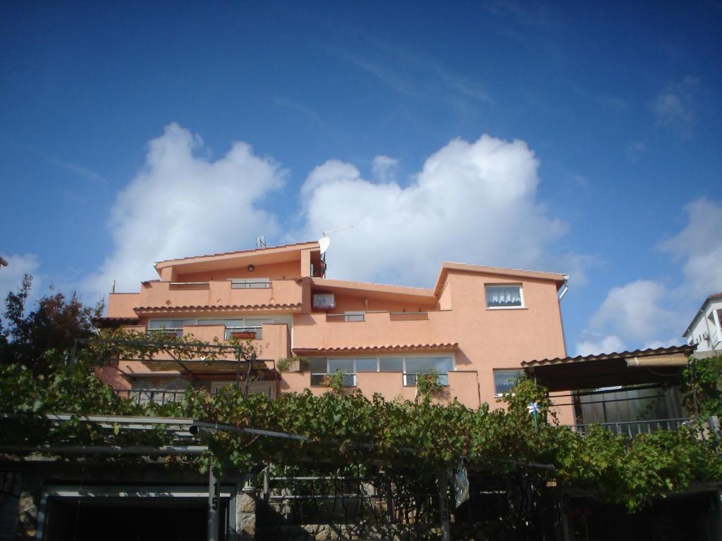 a pink building with a blue sky in the background at Apartments Mory in Kornić