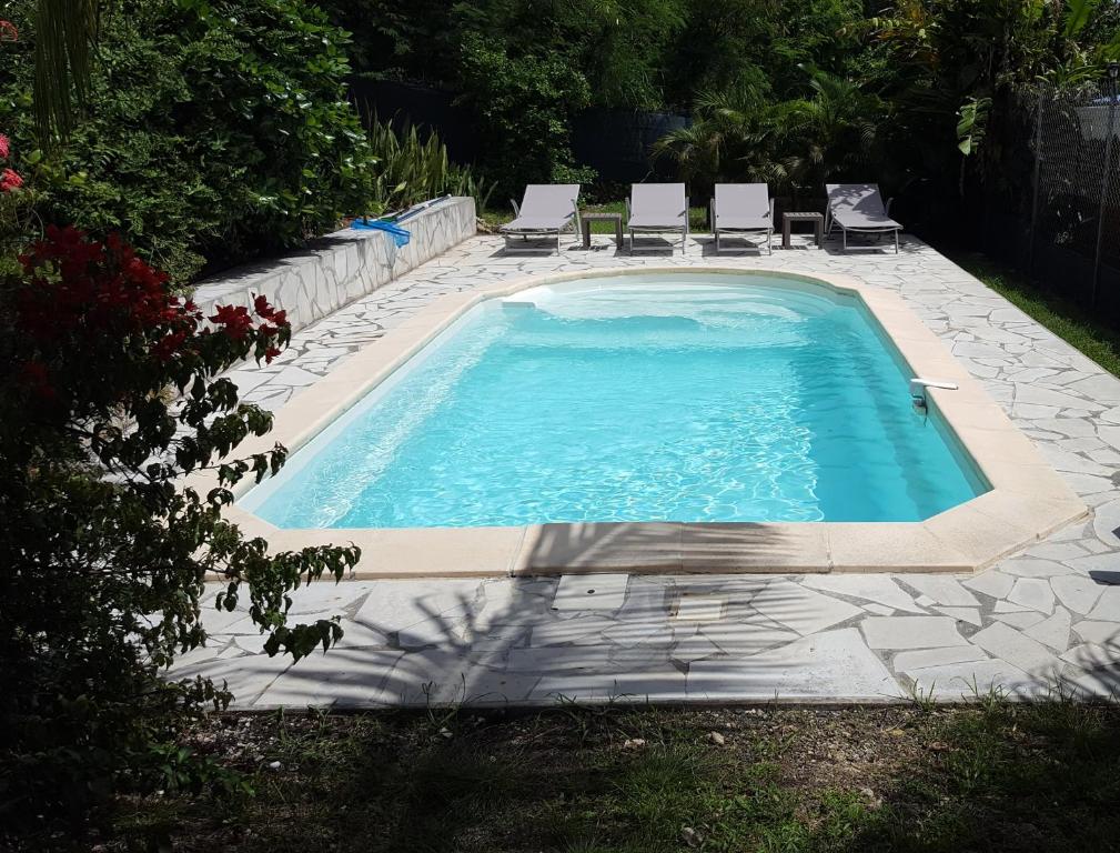 una piscina con 2 sillas y una piscina en Villa Alizia, en Saint-François