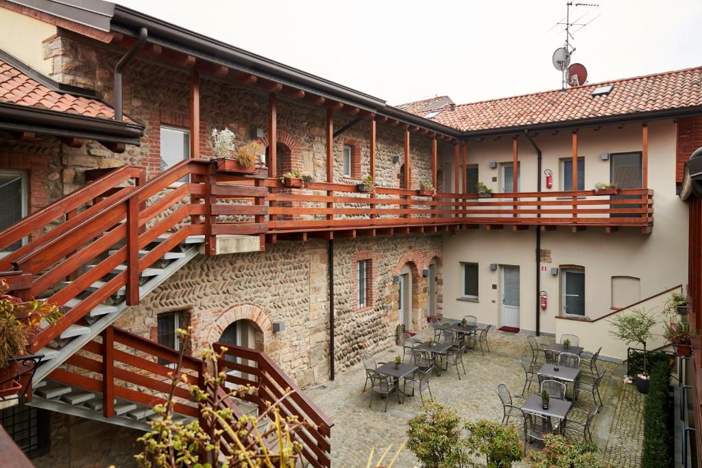 einen externen Blick auf ein Gebäude mit einer Terrasse und einer Terrasse in der Unterkunft San Rocco Hotel in Scanzorosciate