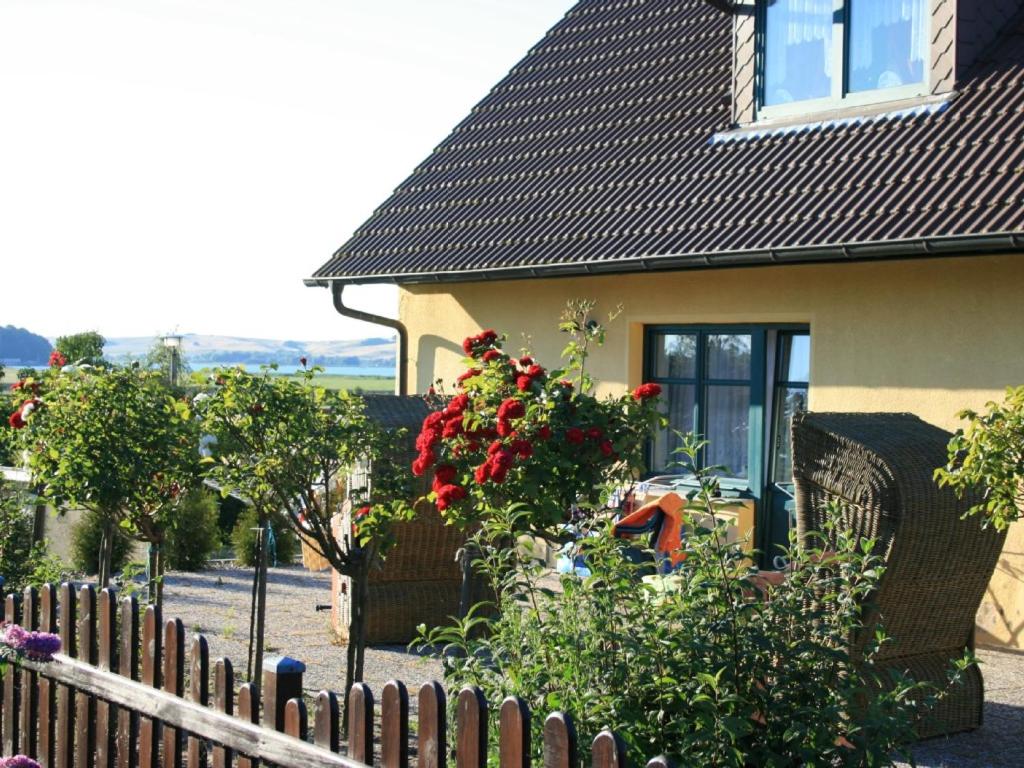 a fence in front of a house with flowers at Haus Fernsicht in Thiessow