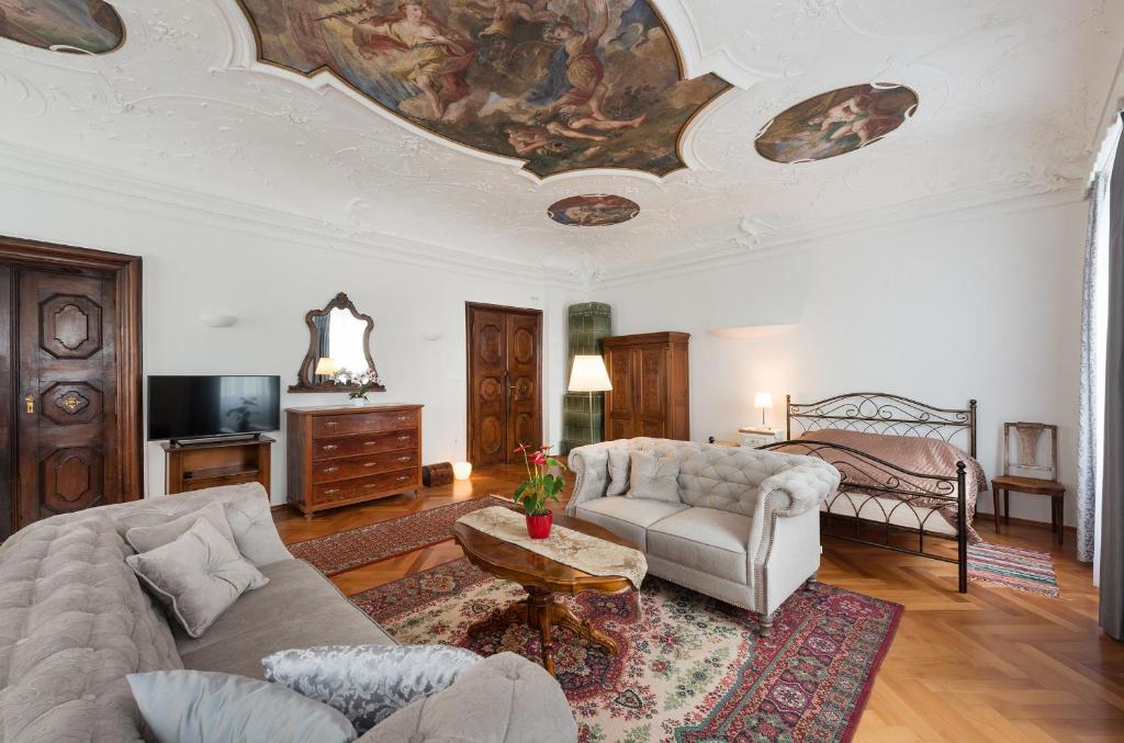 a living room with a couch and a bed at Codelli Deluxe Fresco City Centre APP With Balcony in Ljubljana