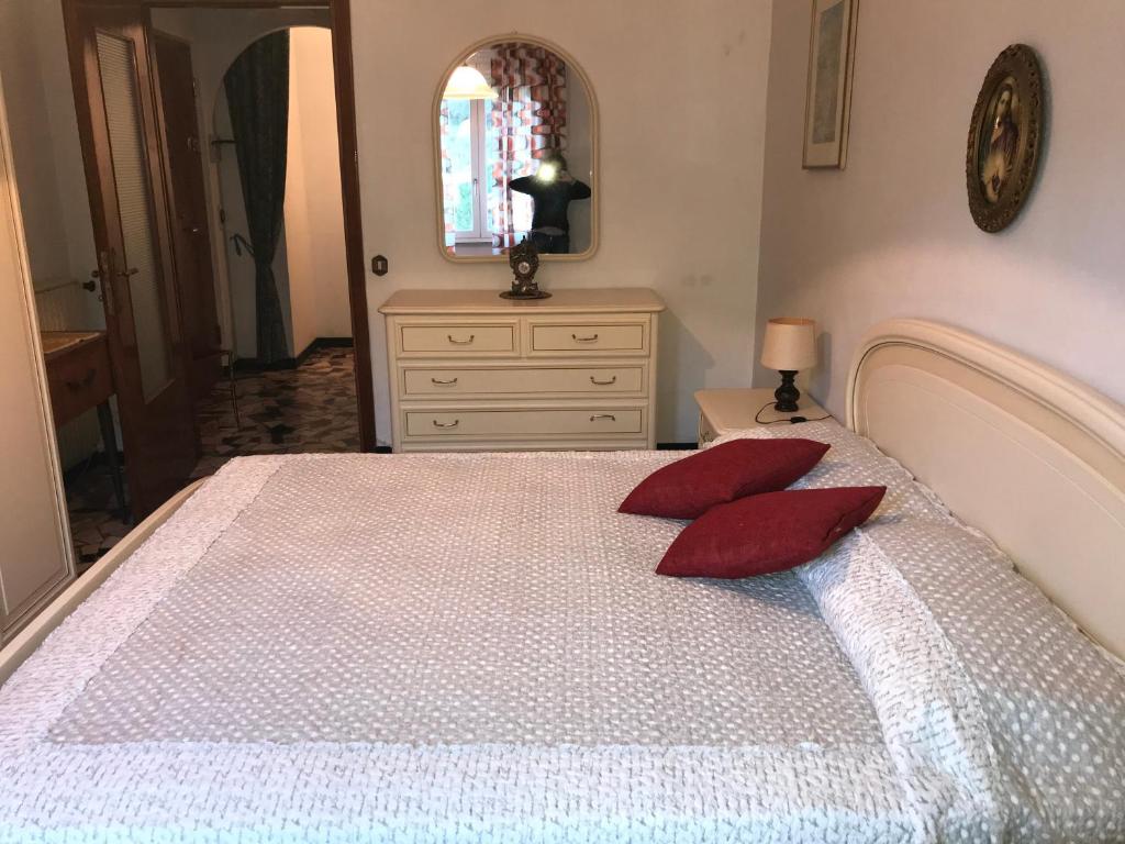 モンテロッソ・アル・マーレにあるAppartamento Jolie - Vicino alle spiagge con ACのベッドルーム1室(白いベッド1台、赤い枕2つ付)