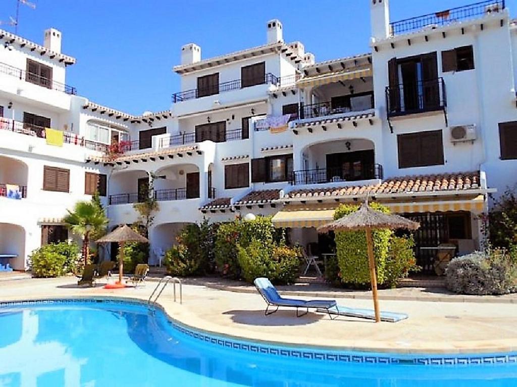 プレヤス・デ・オリフエラにあるApartment Bellavista Cabo Roig with poolの大きな建物で、目の前にスイミングプールがあります。