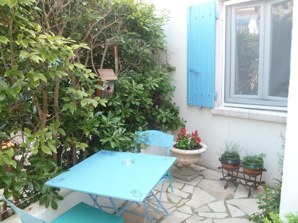 a blue table and chairs on a patio with plants at Hotel Le Méditérranée in Saintes-Maries-de-la-Mer