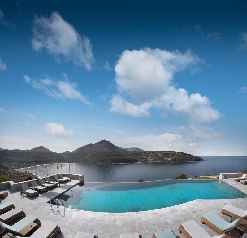 - une piscine avec des chaises et une vue sur une étendue d'eau dans l'établissement Petra & Fos Boutique Hotel & Spa, à Neon Oitilon