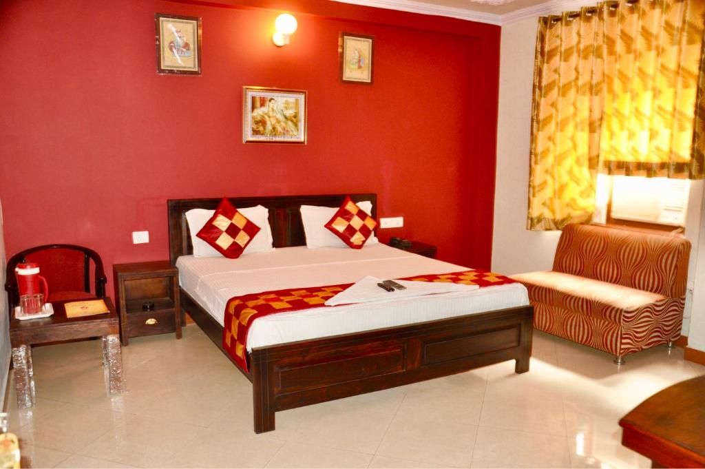 een slaapkamer met een bed en een rode muur bij Hotel Classic Inn Jaipur in Jaipur