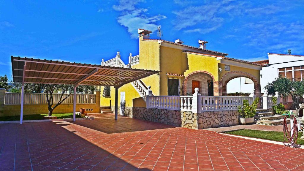 オリーバにあるAnacasa Villa Figuera Kiko Playa CH1099の白柵の大黄色い家