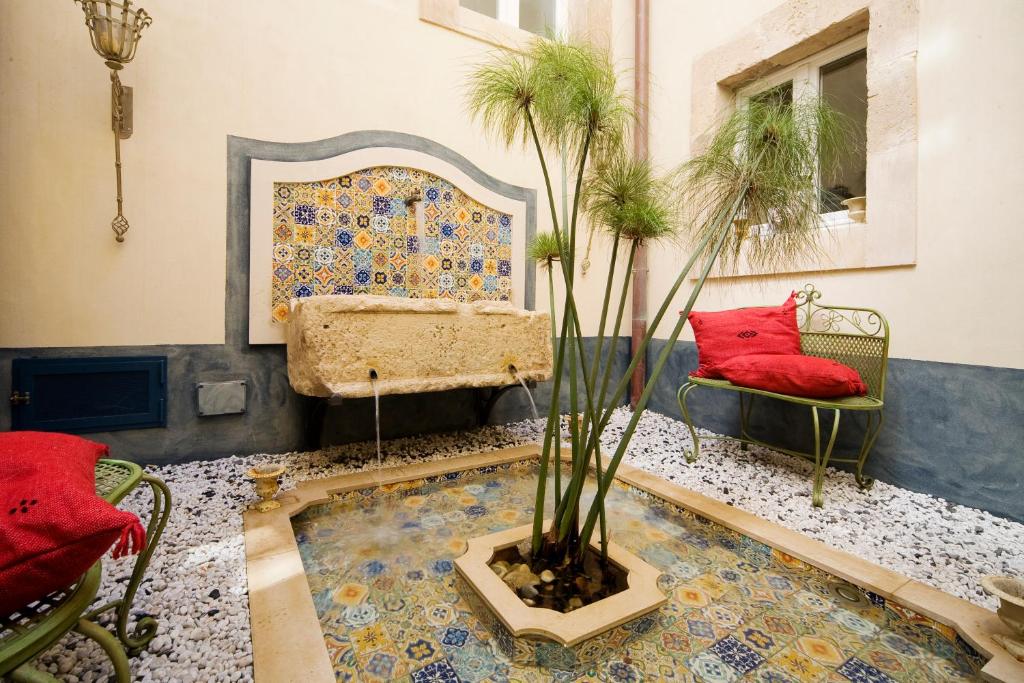 a living room with a couch and a potted plant at Algilà Ortigia Charme Hotel in Siracusa