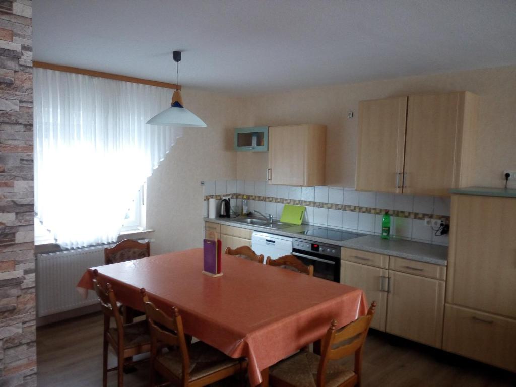 a kitchen with a table and chairs and a kitchen with a table and a table at Monteur - Ferienwohnung Marburg - Biedenkopf - Steffenberg - mit 4 Zimmer und Balkon in Obereisenhausen