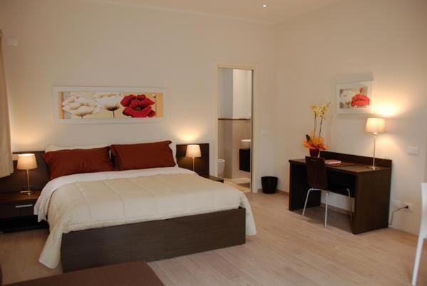 a bedroom with a large bed and a desk and a desk at Il Marlo Suite & Breakfast in Marina di Carrara