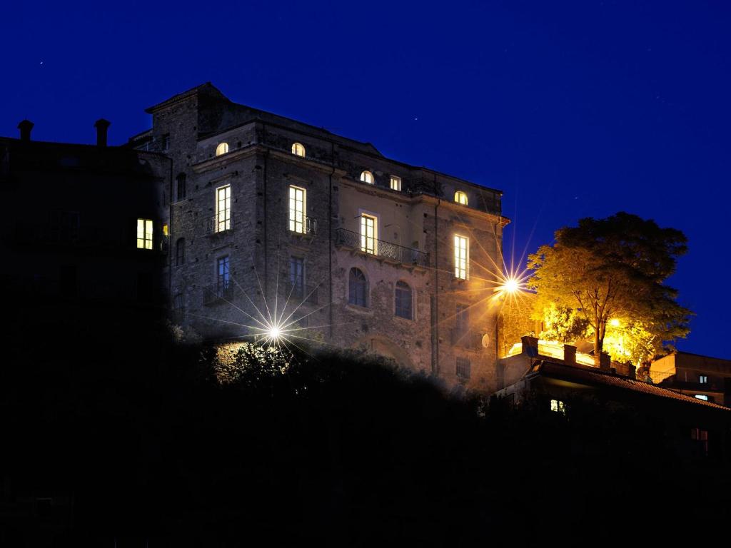 un viejo edificio de noche con luces encendidas en Residenza Matarazzo e Le Sue Soffitte, en Castellabate