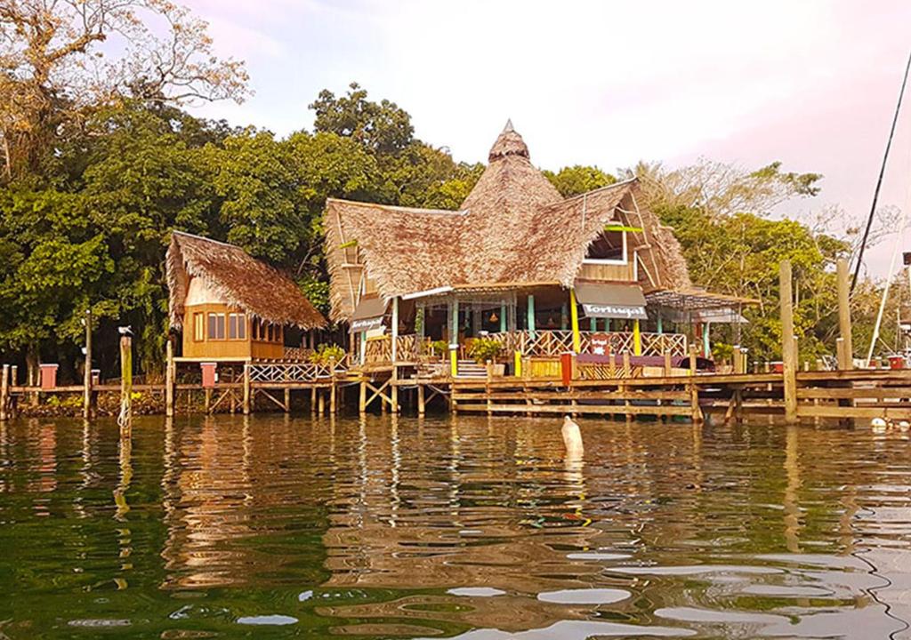 une maison sur un quai d'eau dans l'établissement Tortugal Boutique River Lodge, à Rio Dulce