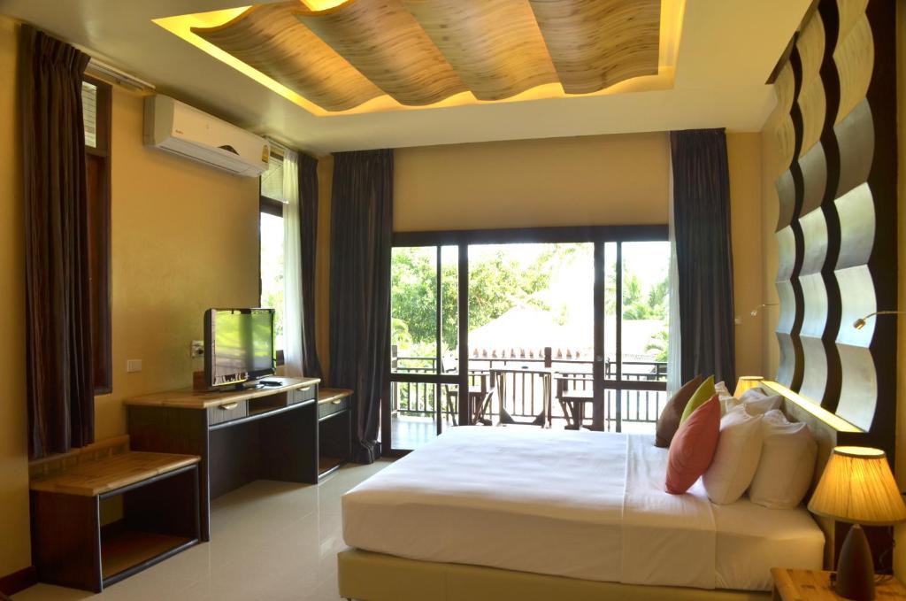 a bedroom with a large bed and a balcony at Palm Leaf Resort Koh Tao in Ko Tao