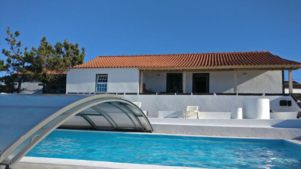 una piscina con un tobogán de agua frente a una casa en Casa do Avô Cristiano en Madalena