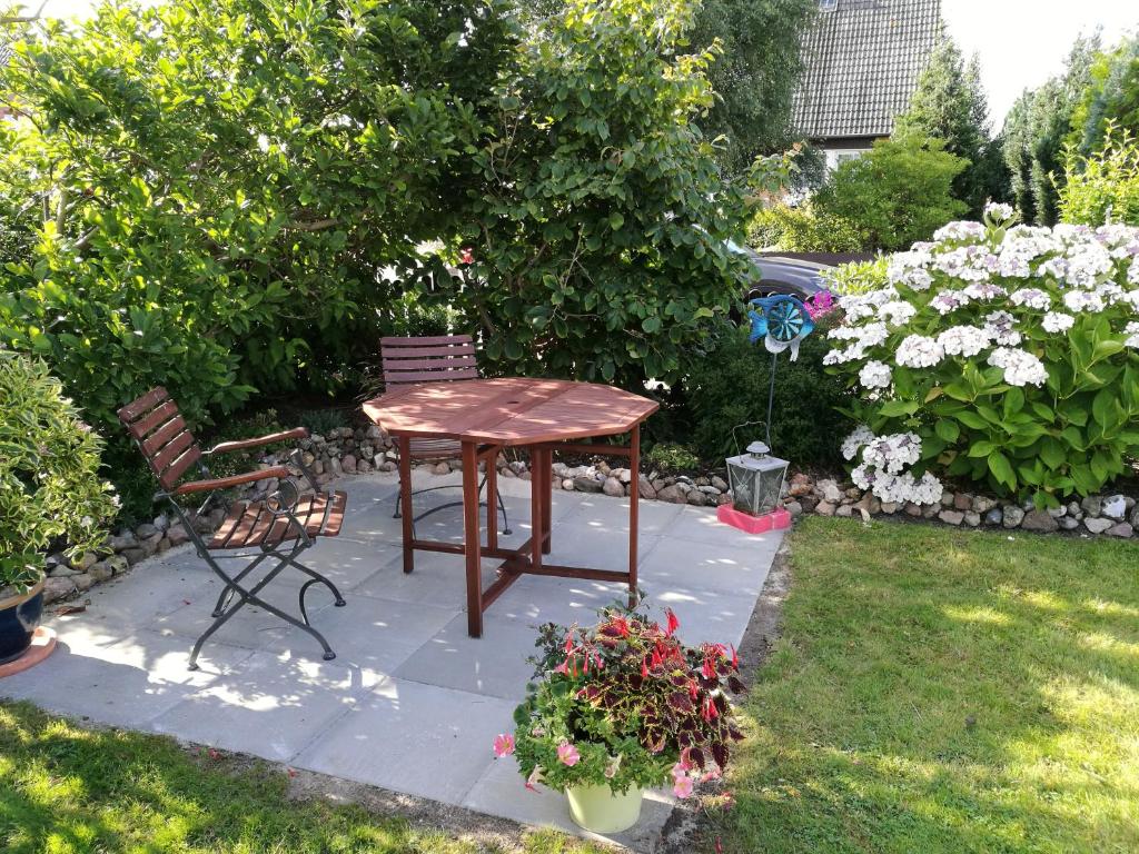 einen Tisch und einen Stuhl in einem Garten mit Blumen in der Unterkunft Haus Haeger in Dahme