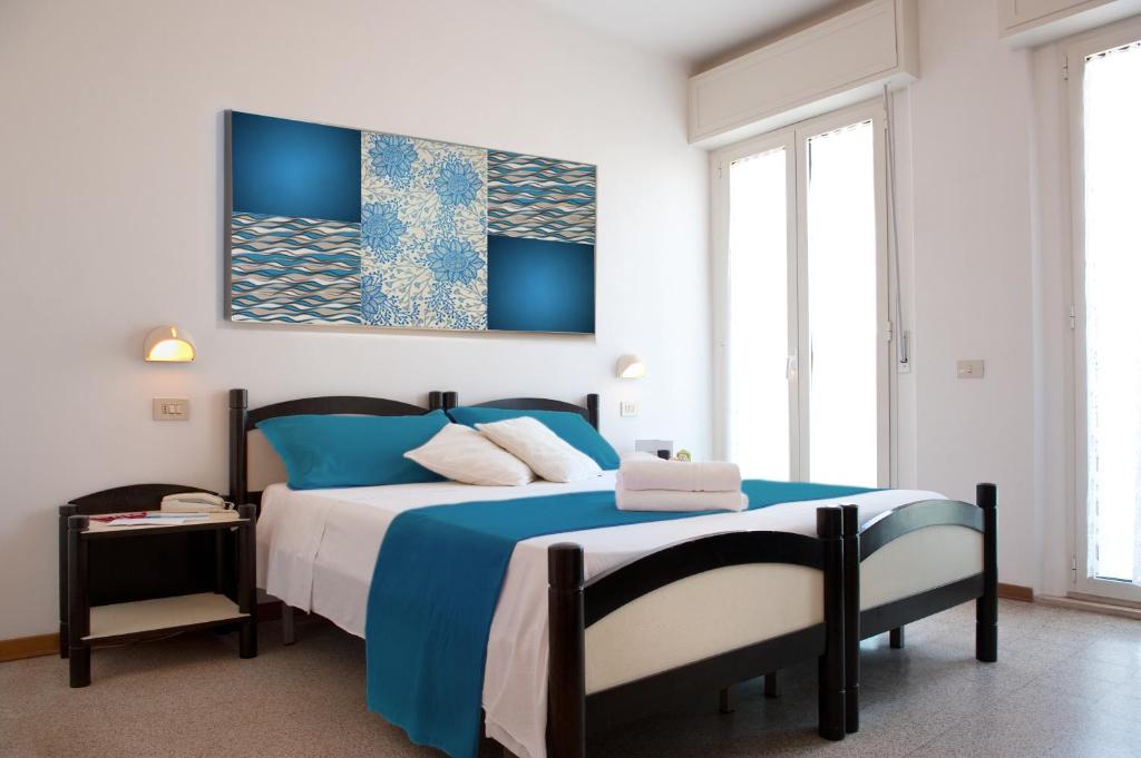 カットーリカにあるHotel Rizのベッドルーム1室(青と白の大型ベッド1台付)