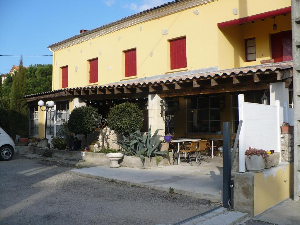 een gebouw met een tafel en stoelen ervoor bij Auberge La Pignata in Montélimar