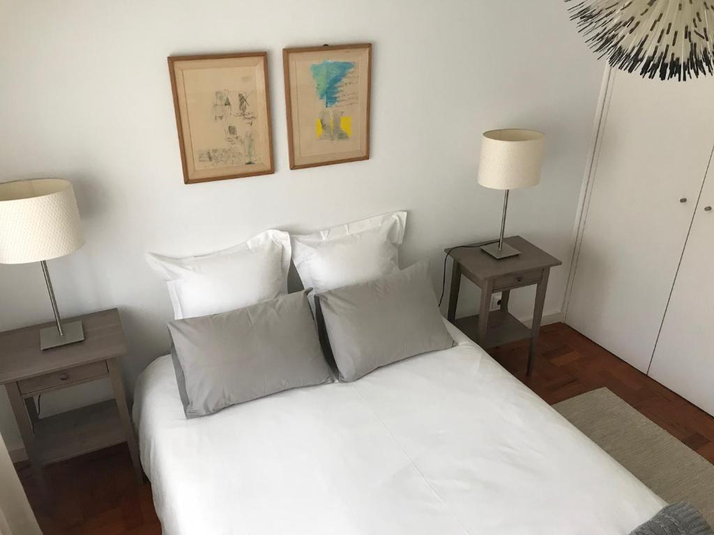 a bedroom with a white bed with two lamps at Beachfront apartment in Porto