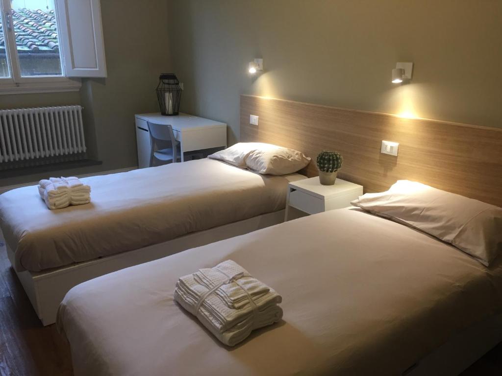 2 Betten in einem Hotelzimmer mit Handtüchern darauf in der Unterkunft Leon Rosso Flat in Florenz