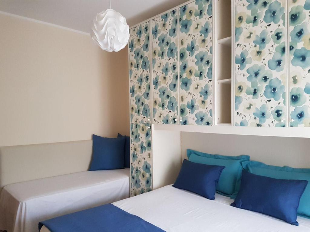 two beds in a room with blue pillows at Appartamento Vacanza Gliaca in Piraino