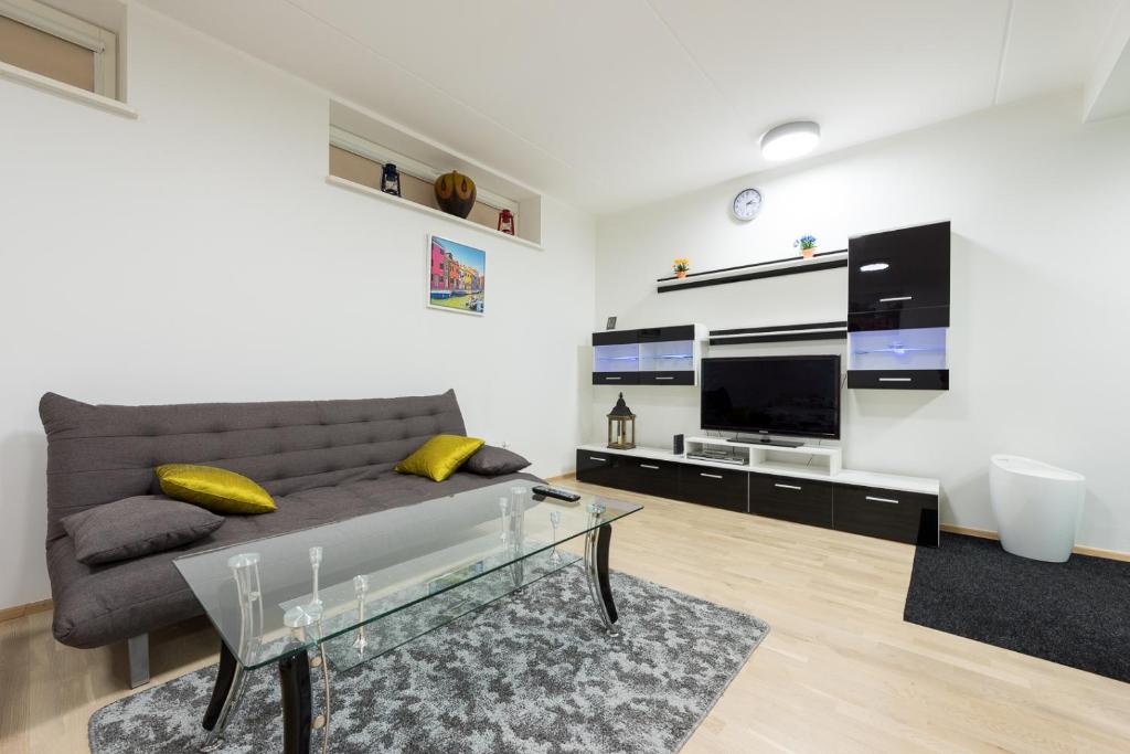 a living room with a couch and a glass table at Telliskivi apartment 16 in Tallinn