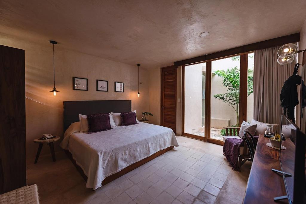 um quarto com uma cama e uma janela grande em Colonte Hotel Origen em Valladolid