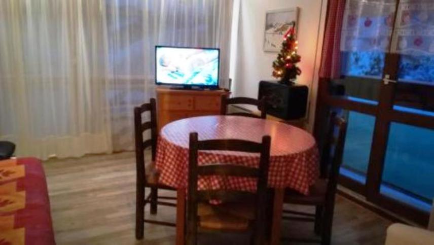 a dining room with a table and a television at appartement in Métabief