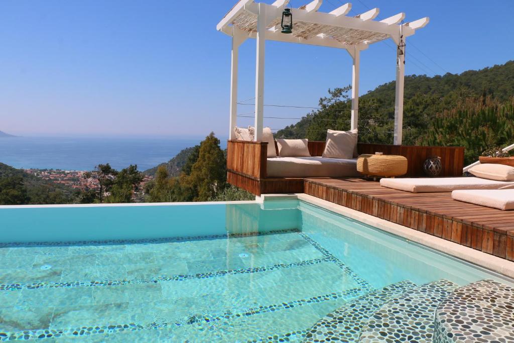 a villa with a swimming pool and a pergola at Ölüdeniz Loft - Adults Only in Oludeniz
