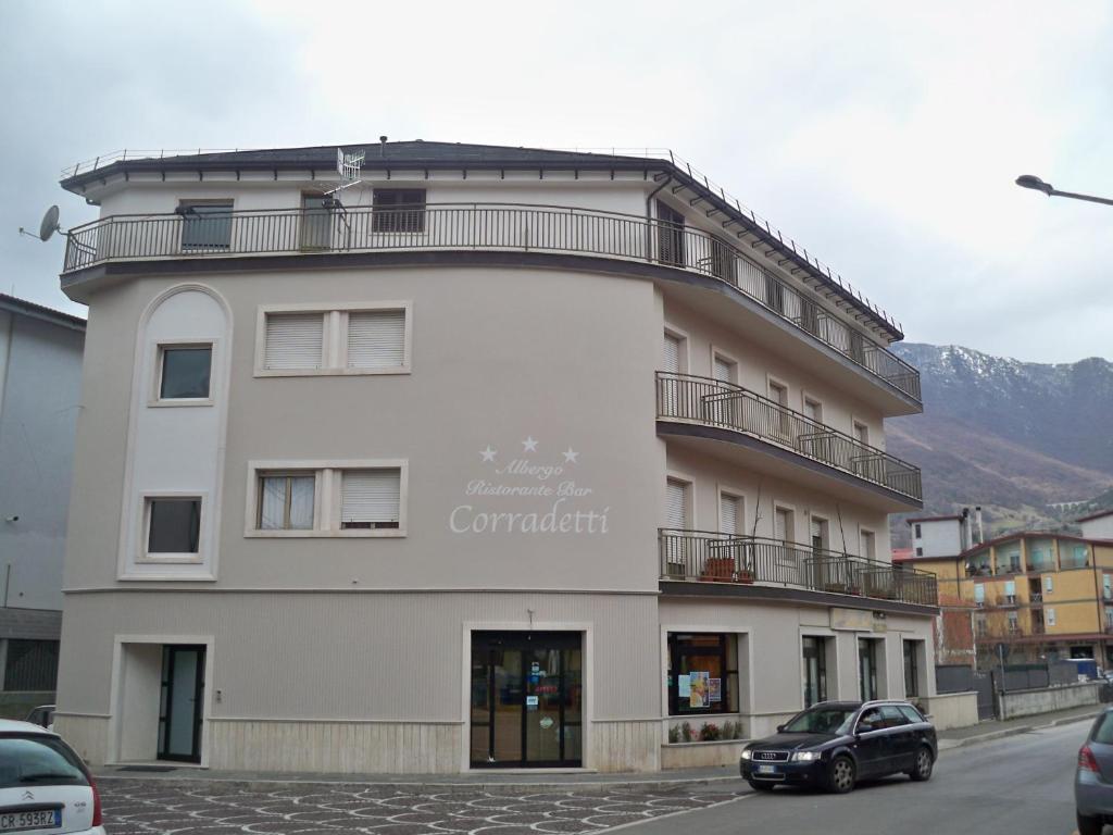 a white building with a car parked in front of it at Albergo Corradetti in Castel di Sangro