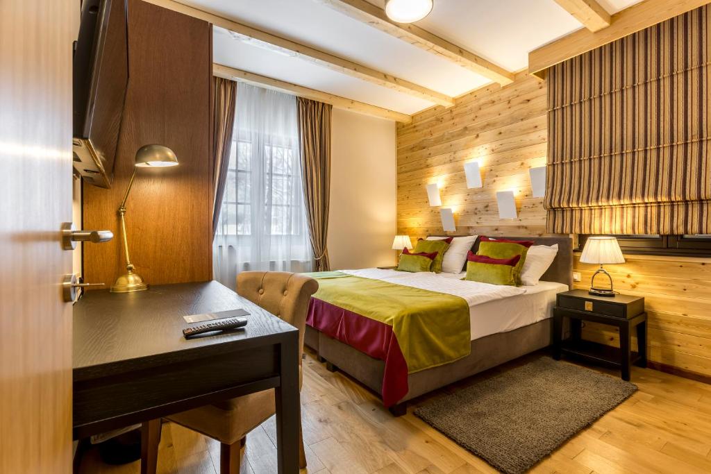una camera d'albergo con letto, scrivania di Fenomen Plitvice Resort a Laghi di Plitvice
