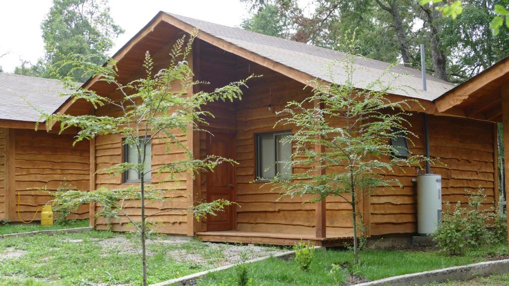 a log cabin with a porch and a window at Cabañas Huenehue in Panguipulli